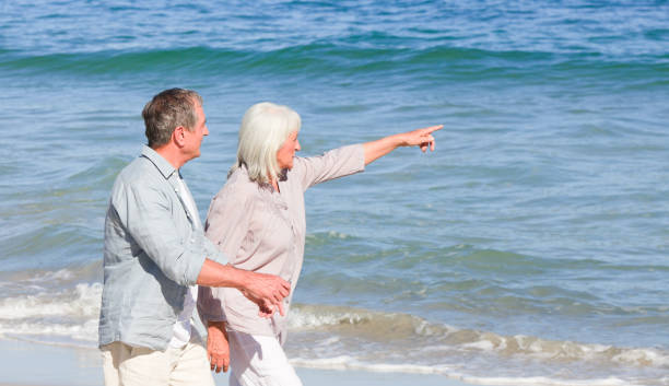 istock Elderly couple walking on the beach 855505214