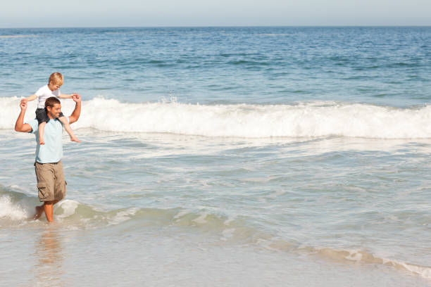 istock Father giving son a piggyback on the beach 855505658