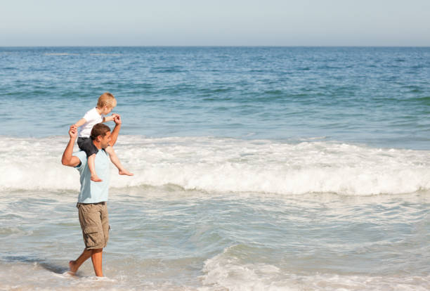 istock Father giving son a piggyback on the beach 855505696