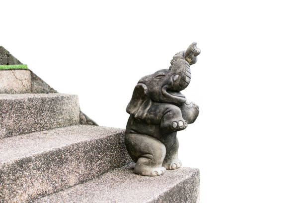 Statue of an elephant on a ladder on a white background.