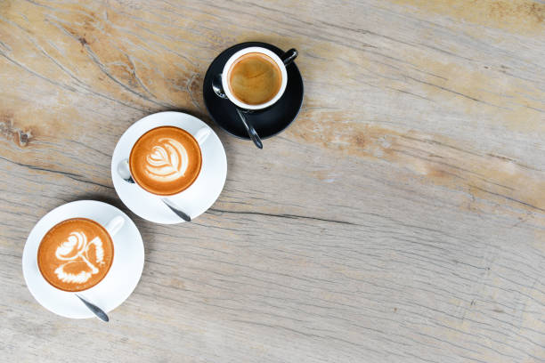 istock Three coffee cup with latte art rose flower shape in the first cup another cup is hearth and leaf pattern,the last in black cup is black coffee 855515620