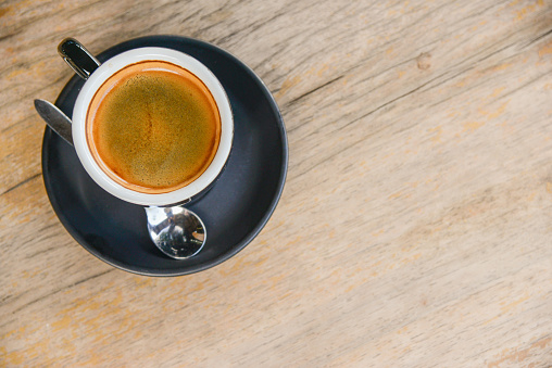 A cup of black coffee in coffee break time on wooden table background.