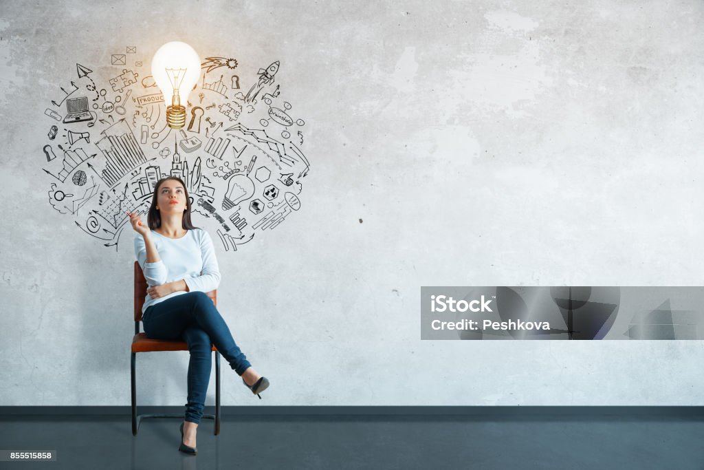 Leadership concept Thoughtful young woman sitting in concrete interior with creative business sketch and shadow. Leadership concept Contemplation Stock Photo