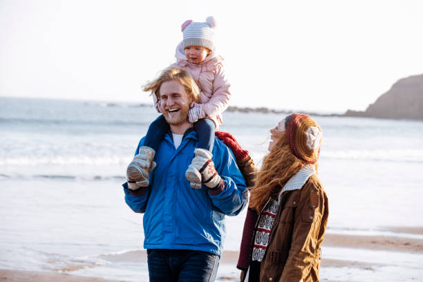 istock Two - Generation Family Walking Along the Beach 855517574