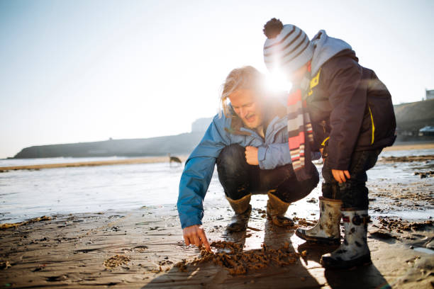 Father and Son Drawing in the Sand on a Winter's Day