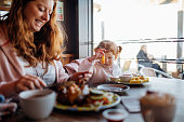 Mother and Daughter Enjoying Food at a Beach Cafe