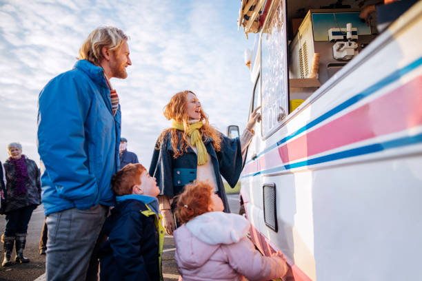 jeune famille à une camionnette de glace - camionnette de vendeur de glaces photos et images de collection