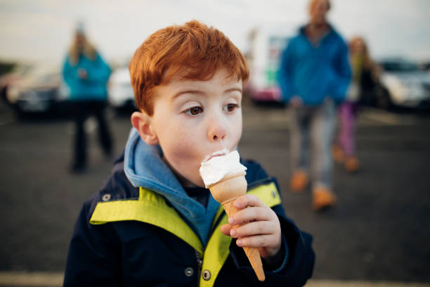 petit garçon, manger des glaces sur la côte - ice cream people food recreational pursuit photos et images de collection