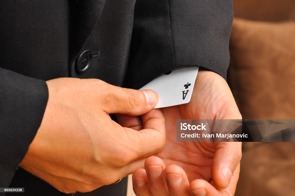 The man's hand takes off ace from sleeve Ace from sleeve Unfairness Stock Photo