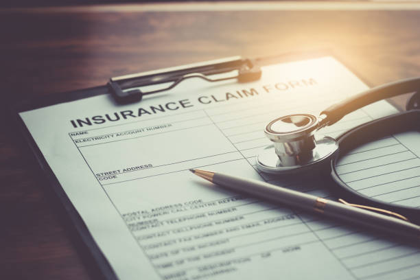 formulario de reclamación de seguro médico con estetoscopio en enfoque selectivo de la mesa de madera - healthcare and medicine bill claim form insurance fotografías e imágenes de stock