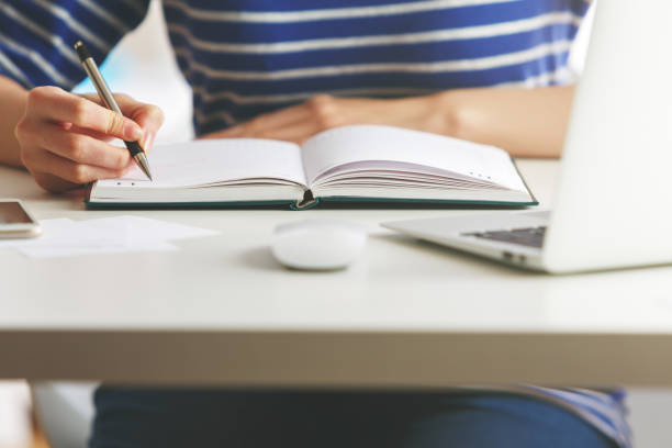 istock Woman writing in hardcover organizer 855525330