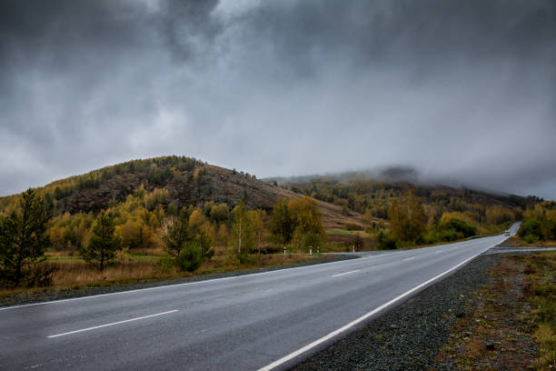 istock Road in the mountains with low clouds 855532186