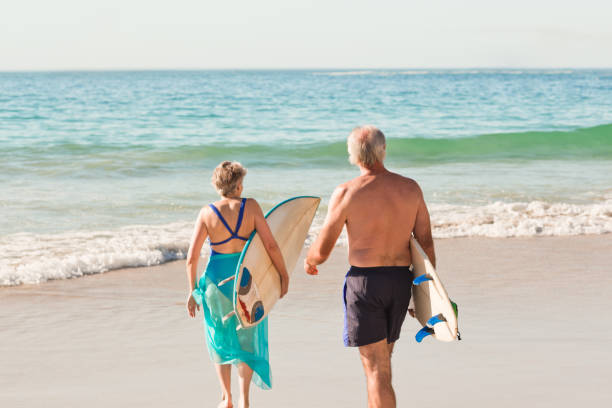 istock Couple with their surfboard on the beach 855535864