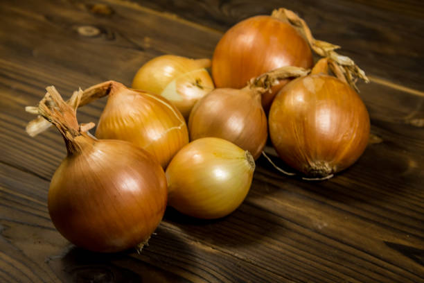 istock Raw onion on wooden table 855536542