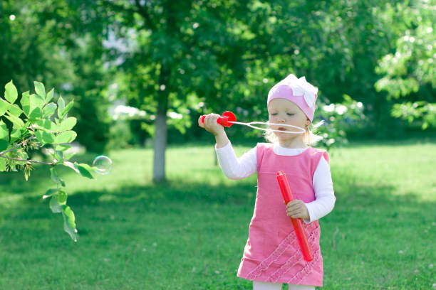 istock A little girl is learning to blow bubbles. 855536970