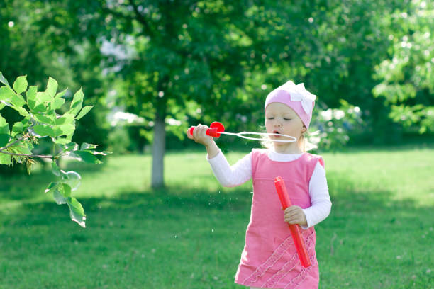 istock A little girl is learning to blow bubbles. 855536988