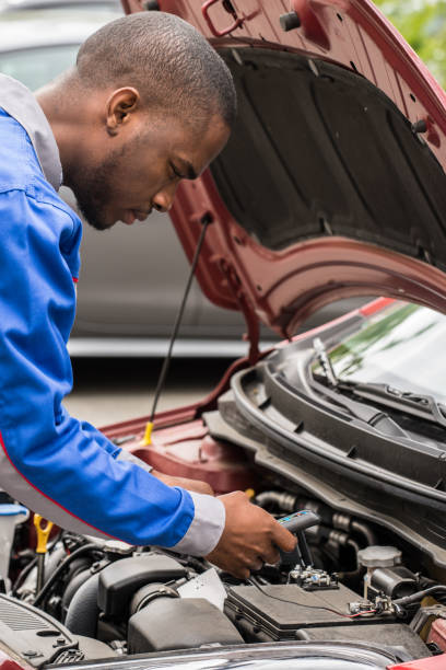 istock Mechanic Checking Car Battery With Multimeter 855539410