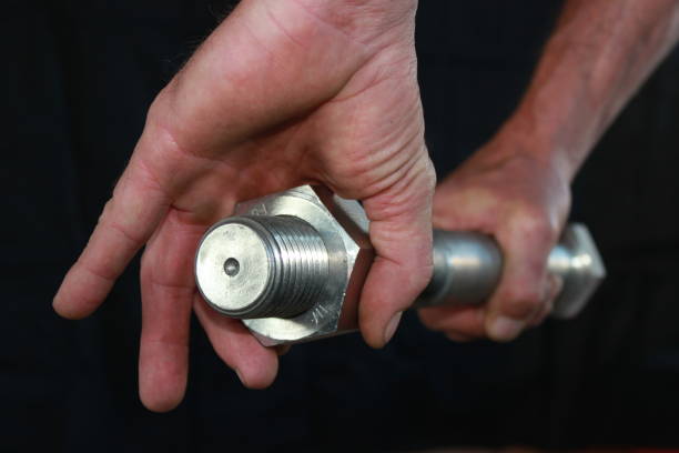 istock Large steel bolt in a mans hands 855540534