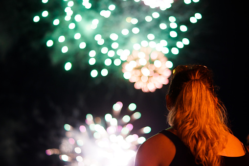 A young woman watches fireworks