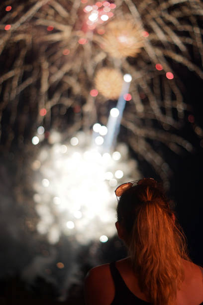 istock A young woman watches fireworks 855543498