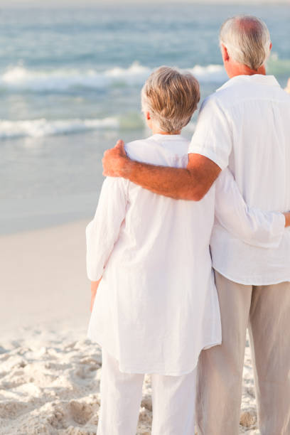 istock Man hugging his wife on the beach 855544224
