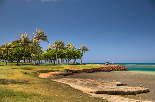 Oahu: Magic Island and the Pacific Ocean in Honolulu, Oahu, Hawaii USA.  Magic Island is a small manmade peninsula in Honolulu, Hawaii, adjacent to Ala Moana Beach Park and the Ala Wai Yacht Harbor. It was created in 1964 as the site of a resort complex, but was subsequently converted to a park.