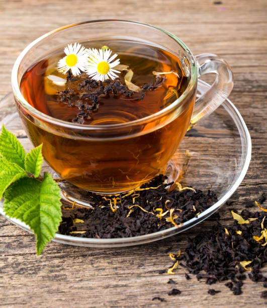 glass cup tea with camomile flower and mint leaf, on brown wooden palette - oregano freshness herb brown imagens e fotografias de stock