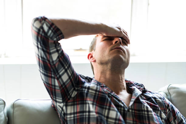istock Young man suffering from headache at home 855554170
