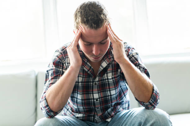 istock Young man suffering from headache at home 855554344