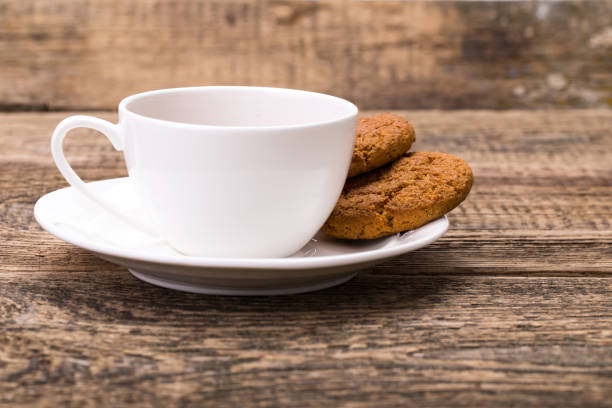 istock Ivory tea cup with sweet cookie on wooden palette 855557018