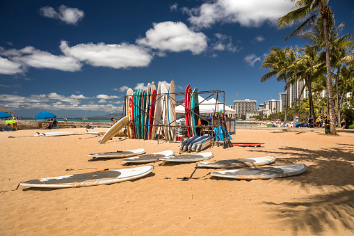 Oahu: Surfboards along the Pacific Ocean shore of Waikiki beach in Honolulu, Oahu, Hawaii USA.  Waikiki is a beachfront neighborhood of Honolulu, on the south shore of the island of Oahu, in Hawaii, United States. Waikiki is most famous for Waikiki Beach, but it is just one of six beaches in the district, the others being Queen's Beach, Kuhio Beach, Gray's Beach, Fort DeRussy Beach and Kahanamoku Beach.