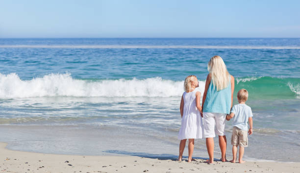 istock Joyful family walking on the beach 855564136