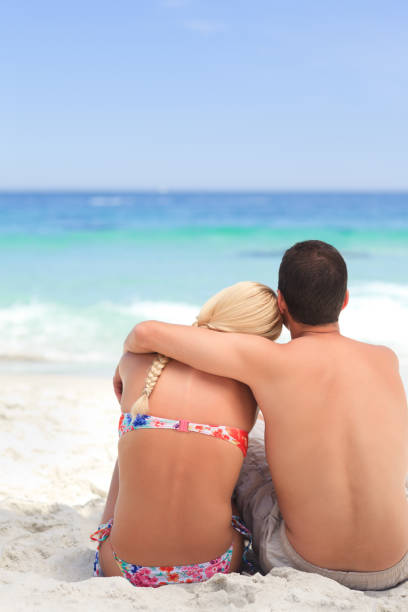 istock Man hugging his girlfriend while they are looking at the sea 855568406