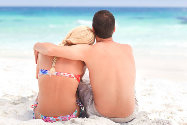 istock Man hugging his girlfriend while they are looking at the sea 855568444
