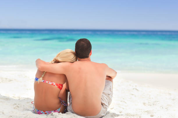istock Man hugging his girlfriend while they are looking at the sea 855568524