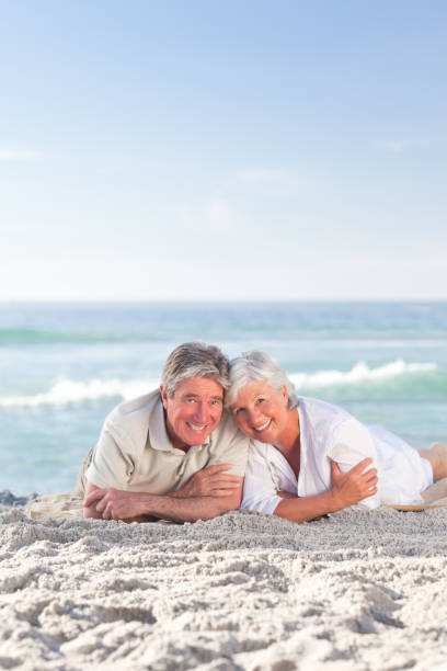 istock Mature couple lying down on the beach 855578490