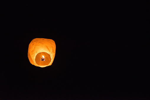 Group of friends launching a paper lantern at night in Quebec Canada. Family