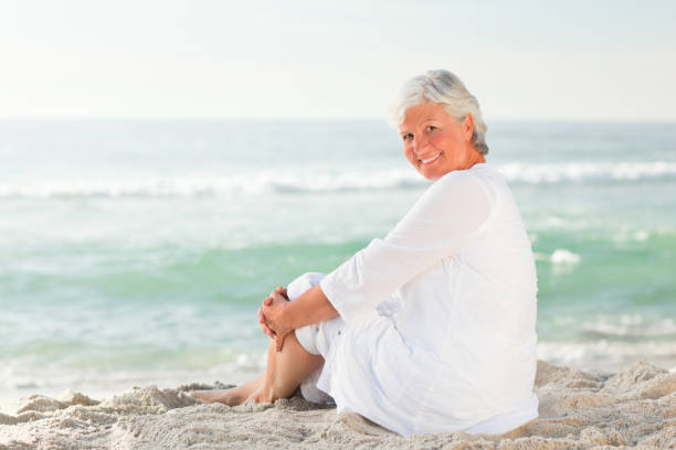 istock Woman sitting on the beach 855581588