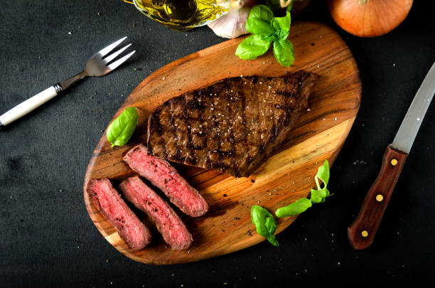 sliced rare steak basil spice cutting board - flank steak imagens e fotografias de stock