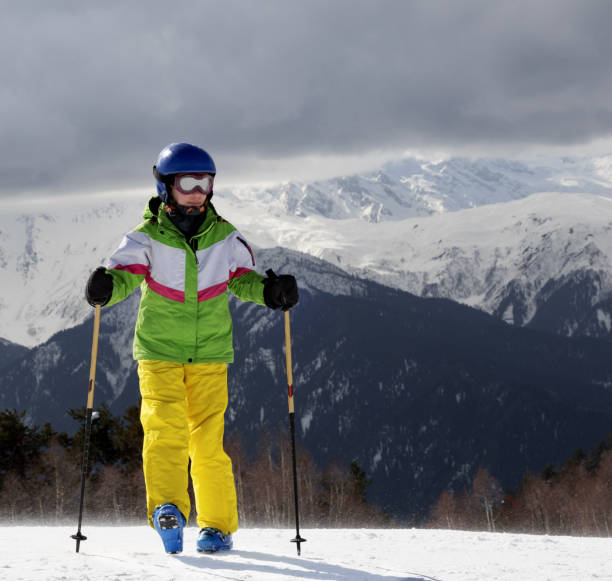 istock Young skier with ski poles in sun mountains and gray sky before storm 855587388