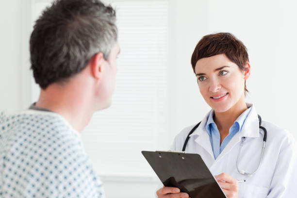 istock Doctor talking to a male patient holding a chart 855591304