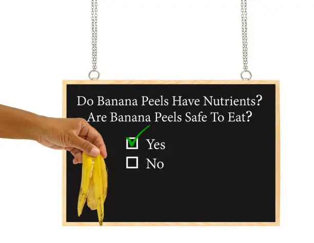 Hand holding banana peel blackboard (Do banana peels have nutrients, are they safe to eat?) checked yes