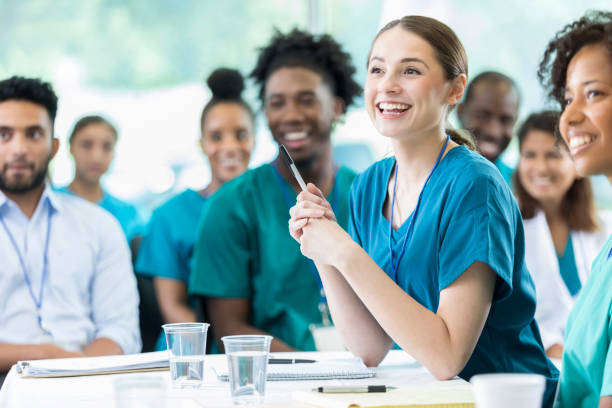 Attentive nursing students in class Cheerful Hispanic female nursing students smiles as she listens to a professor's lecture. healthcare management stock pictures, royalty-free photos & images