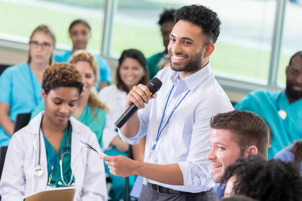 istock Young male doctor asks a question during medical seminar 855597390