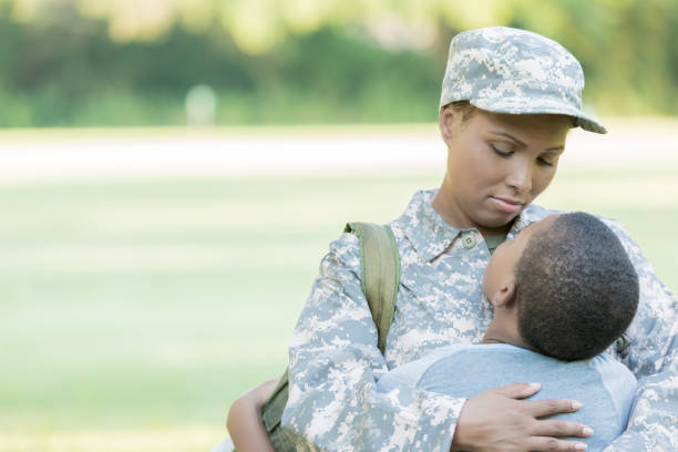 istock Mid adult woman hugs son before her deployment 855600904