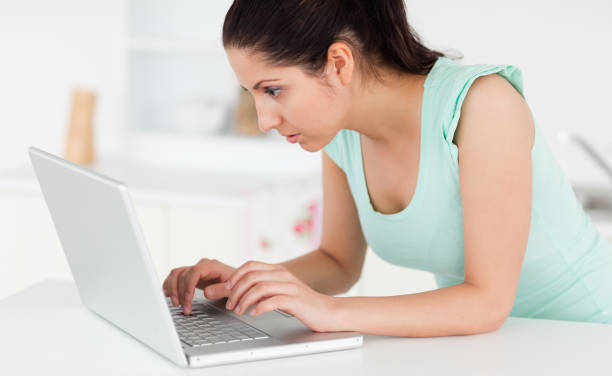 istock Young woman at her laptop in kitchen 855607980