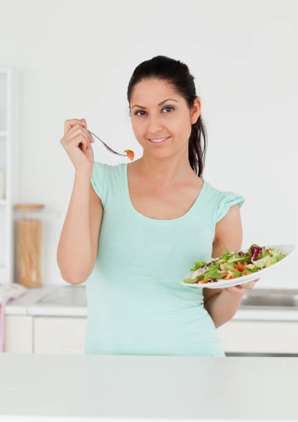 istock Young adult eating salad 855611662