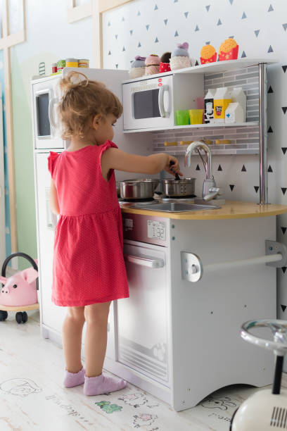 Young girl playing role in kitchen stock photo