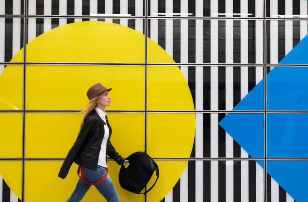 Young woman and yellow background. City life. This image is taken at Tottenham Court Road public subway station in London, United Kingdom.