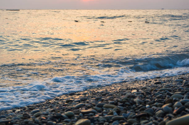 istock Amazing sea sunset on the pebble beach, the sun, waves, clouds 855620972
